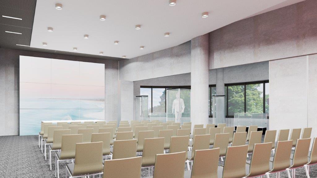 Projekt wnętrza nowego budynku Archiwum Państwowego w Koszalinie, widok na salę konferencyjną, widoczne rzędy krzeseł, na wprost ekran, u góry, na suficie punkty oświetleniowe, po prawej stronie duże okna 