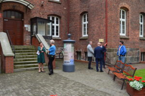 6 osób stoi przy wejściu do budynku archiwum