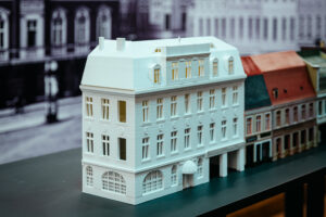 Ciąg budynków wydrukowanych w drukarce 3D w zbliżeniu. Makieta prezentuje budowle z lat 30. XX wieku.