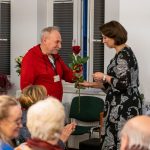 Dyrektor Archiwum Państwowego w Koszalinie Katarzyna Królczyk wręcza różę pracownikowi Archiwum Ryszardowi Marczykowi w podziękowaniu za wieloletnią pracę